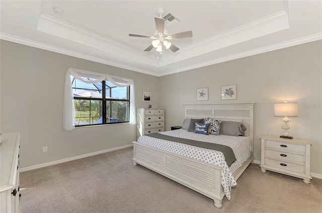 bedroom featuring ceiling fan, crown molding, light colored carpet, and a tray ceiling