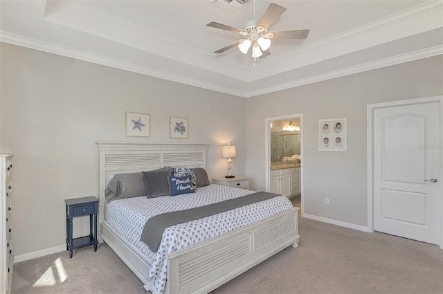 carpeted bedroom with ceiling fan, ensuite bath, ornamental molding, and a raised ceiling