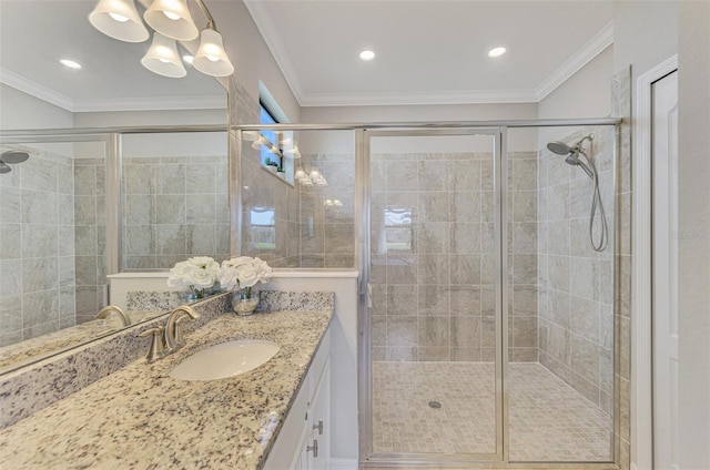 bathroom featuring a shower with door, crown molding, and vanity