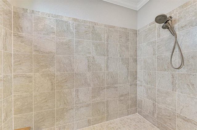 bathroom with crown molding and a tile shower