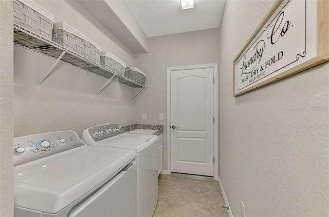 washroom featuring washing machine and dryer, sink, and light tile patterned flooring