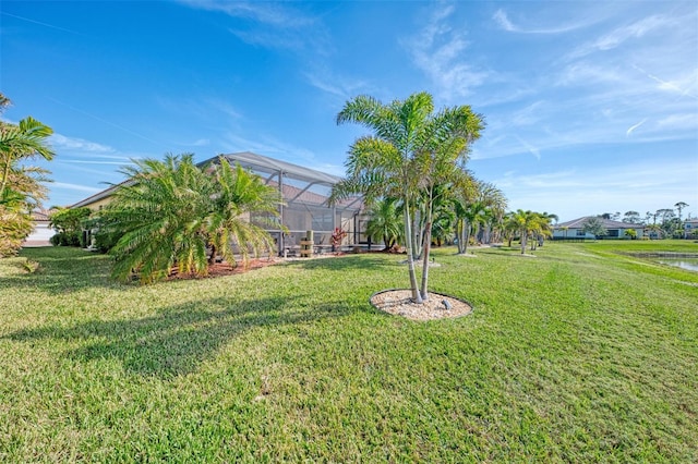 view of yard featuring a lanai and a water view