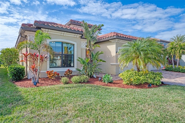 mediterranean / spanish house with a garage and a front lawn