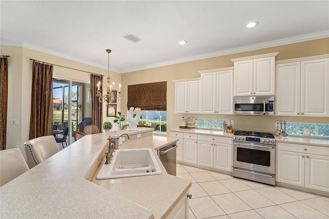 kitchen featuring pendant lighting, stainless steel appliances, ornamental molding, and sink