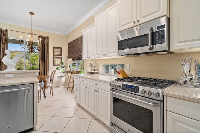 kitchen with white cabinetry, crown molding, a chandelier, light tile patterned floors, and appliances with stainless steel finishes