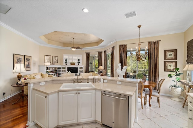 kitchen with dishwasher, sink, light tile patterned flooring, crown molding, and white cabinets