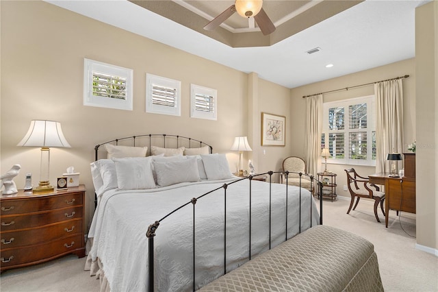 carpeted bedroom featuring multiple windows and ceiling fan