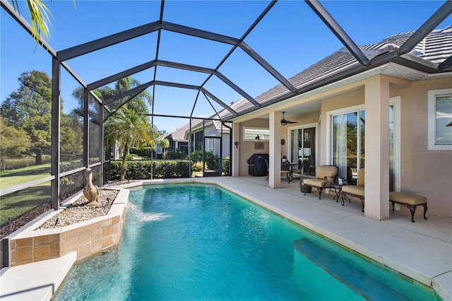 view of pool featuring pool water feature, ceiling fan, glass enclosure, grilling area, and a patio