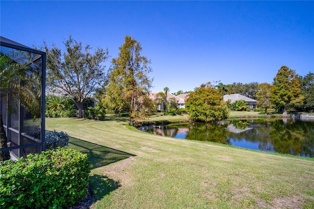 view of yard featuring a lanai and a water view