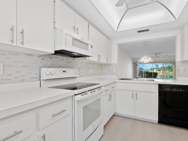 kitchen with white appliances, ceiling fan, decorative light fixtures, white cabinets, and light hardwood / wood-style floors