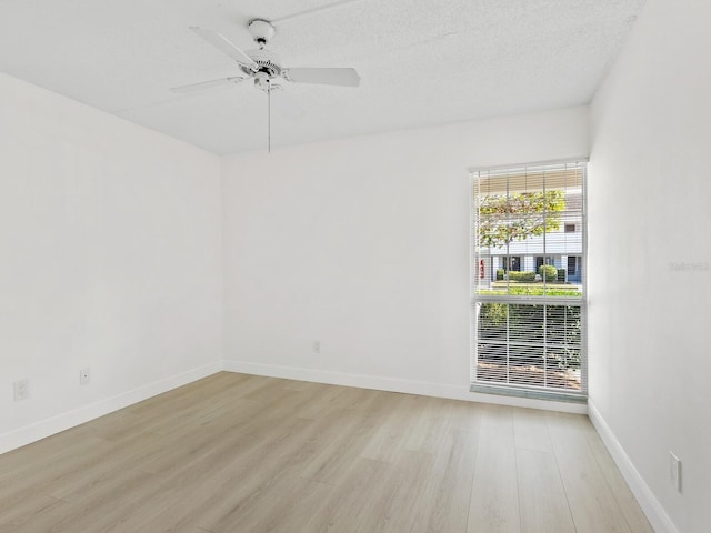 unfurnished room with ceiling fan, light hardwood / wood-style flooring, and a textured ceiling