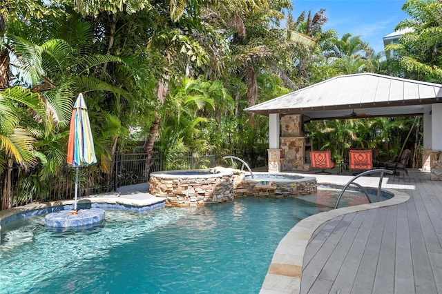 view of pool featuring a gazebo, a deck, an in ground hot tub, and pool water feature