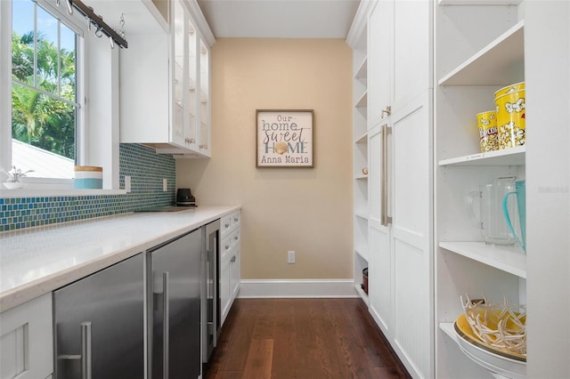 interior space featuring backsplash, white cabinetry, beverage cooler, and dark wood-type flooring