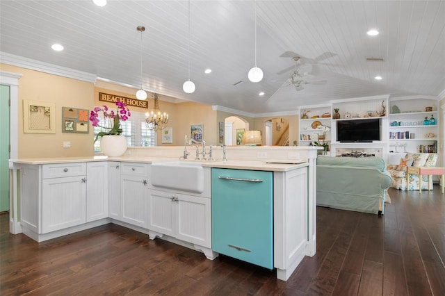 kitchen featuring white cabinets, hanging light fixtures, an island with sink, and vaulted ceiling