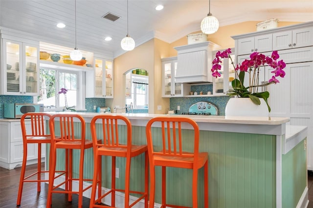 kitchen with pendant lighting, white cabinetry, backsplash, and dark wood-type flooring