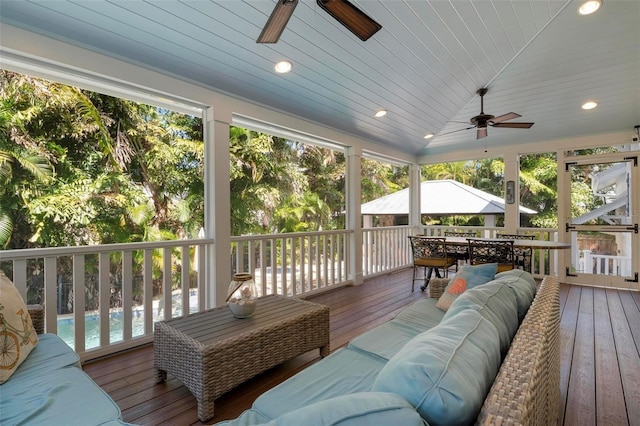 sunroom / solarium with ceiling fan, lofted ceiling, and wooden ceiling