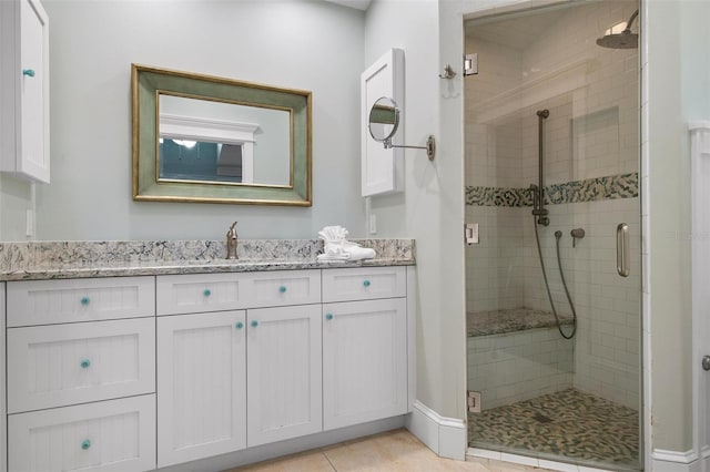 bathroom featuring tile patterned flooring, vanity, and a shower with door