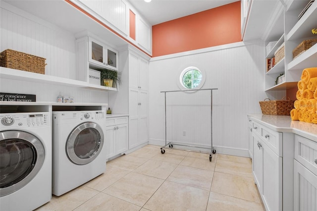 washroom featuring washer and clothes dryer, light tile patterned floors, and cabinets