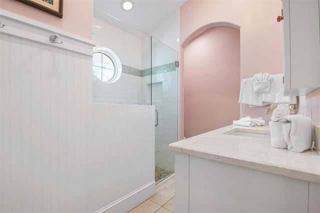 bathroom featuring vanity, tile patterned floors, and a shower with door