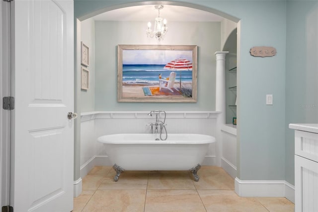 bathroom featuring tile patterned floors, a tub, and a chandelier