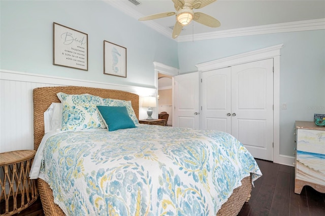 bedroom with a closet, ceiling fan, crown molding, and dark hardwood / wood-style floors