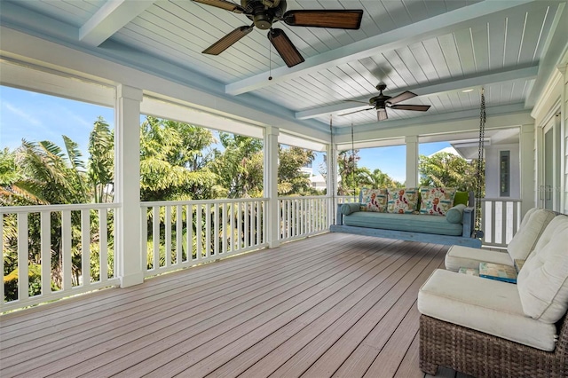 sunroom / solarium featuring beamed ceiling and ceiling fan