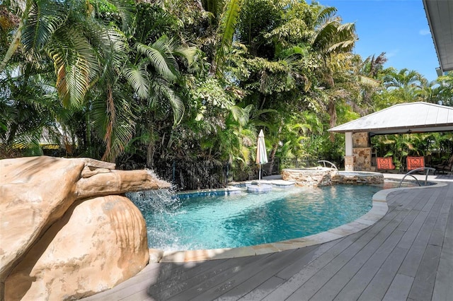 view of swimming pool with a gazebo, pool water feature, a jacuzzi, and a wooden deck