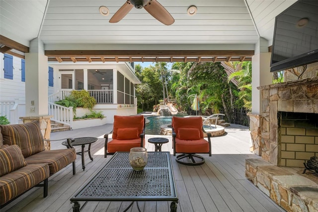 wooden terrace with an outdoor living space with a fireplace, a sunroom, ceiling fan, and pool water feature