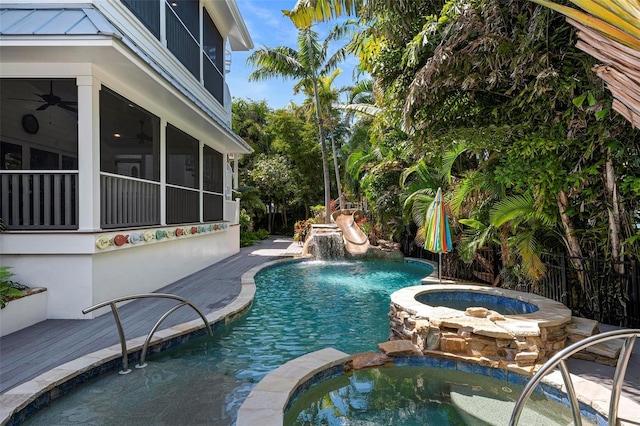 view of swimming pool featuring an in ground hot tub, pool water feature, and a sunroom