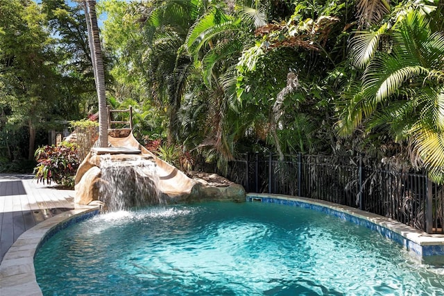 view of swimming pool featuring pool water feature and a deck