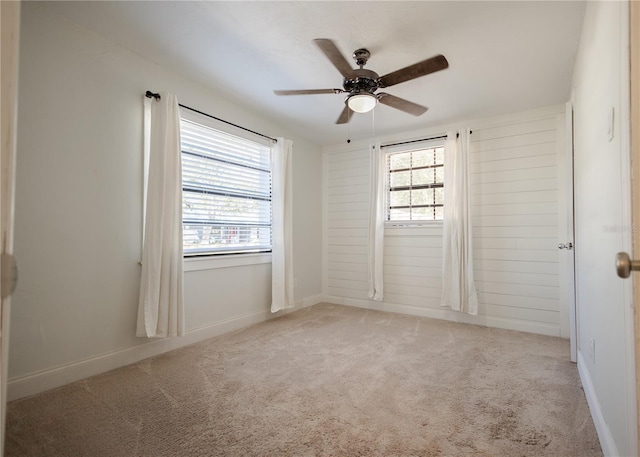 carpeted spare room with ceiling fan