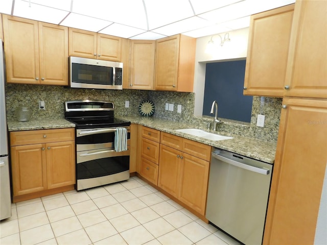 kitchen featuring appliances with stainless steel finishes, backsplash, a drop ceiling, and sink