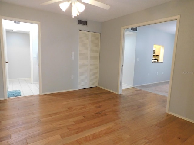 unfurnished bedroom featuring a closet, light hardwood / wood-style flooring, and ceiling fan