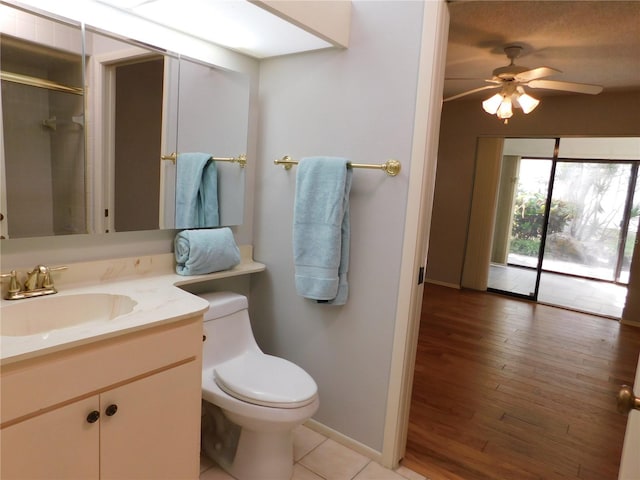 bathroom with hardwood / wood-style floors, vanity, ceiling fan, toilet, and walk in shower