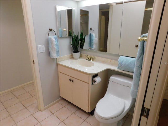 bathroom featuring tile patterned flooring, vanity, and toilet