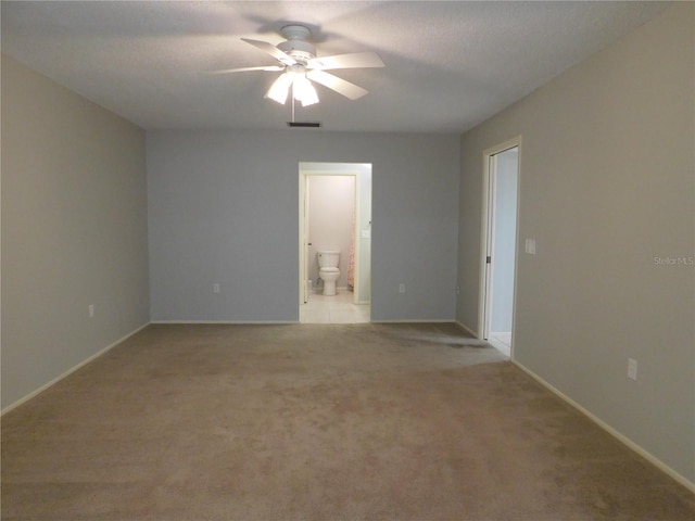 empty room featuring a textured ceiling, light colored carpet, and ceiling fan