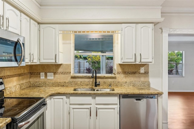 kitchen with white cabinetry, sink, stainless steel appliances, hardwood / wood-style floors, and ornamental molding