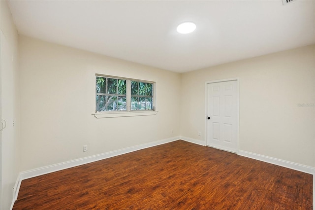 spare room featuring dark wood-type flooring