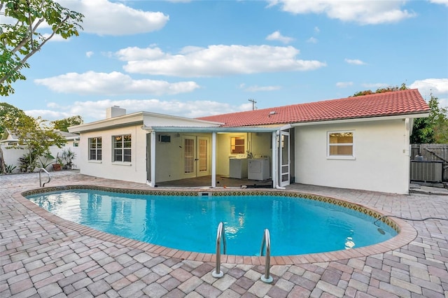 view of swimming pool with french doors, a patio, and central AC