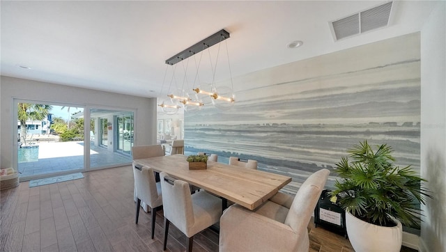 dining room with hardwood / wood-style floors and a chandelier