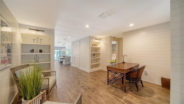 interior space featuring built in shelves and wood-type flooring