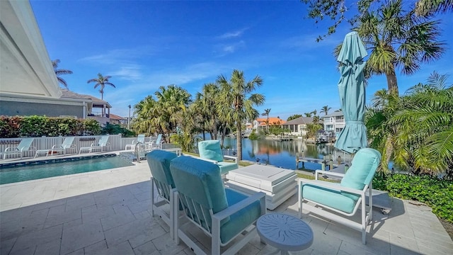 view of patio featuring a water view and a fenced in pool