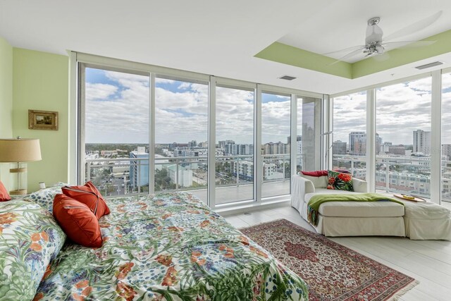 bedroom with ceiling fan, expansive windows, and access to exterior