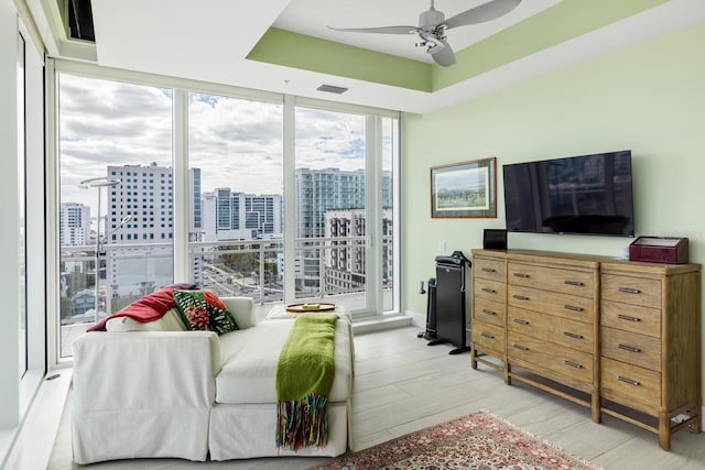 bedroom with floor to ceiling windows, ceiling fan, and light hardwood / wood-style flooring