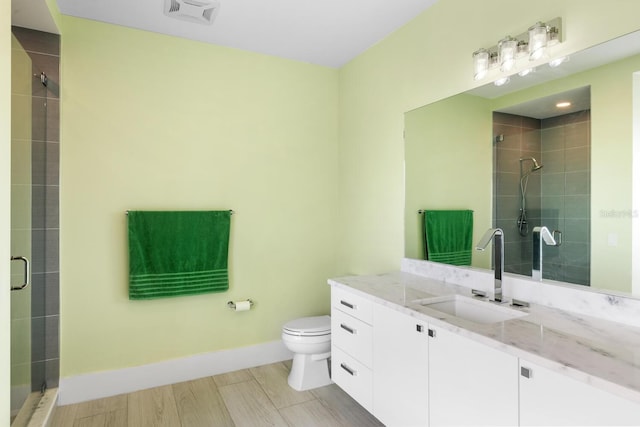 bathroom featuring vanity, an enclosed shower, and toilet