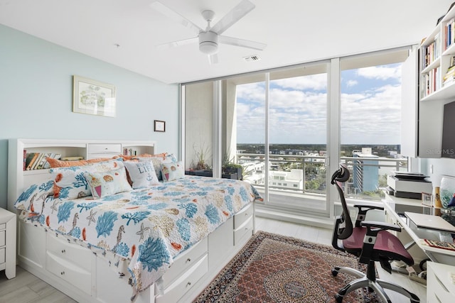 bedroom featuring access to exterior, ceiling fan, expansive windows, and light hardwood / wood-style floors