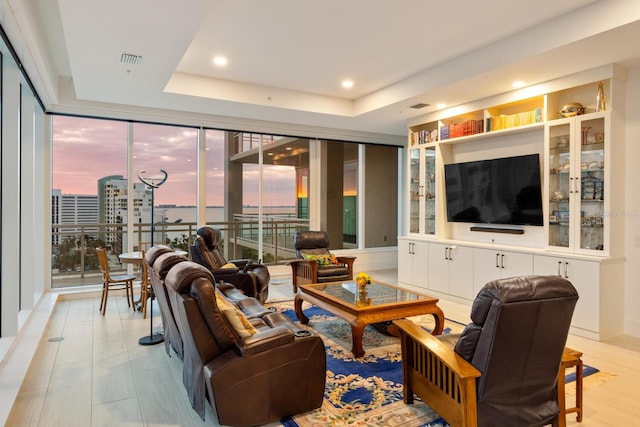 living room with a tray ceiling and expansive windows