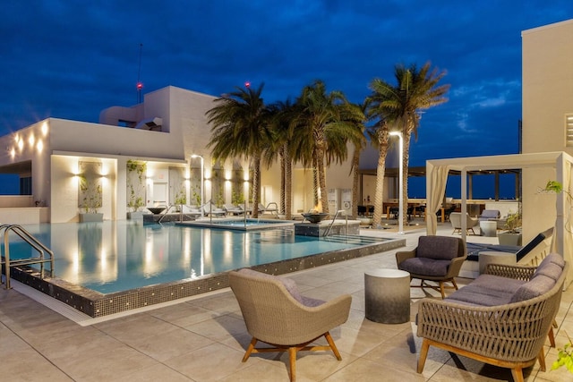 pool at twilight featuring a patio