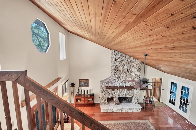 unfurnished living room featuring french doors, hardwood / wood-style floors, lofted ceiling, a fireplace, and wood ceiling