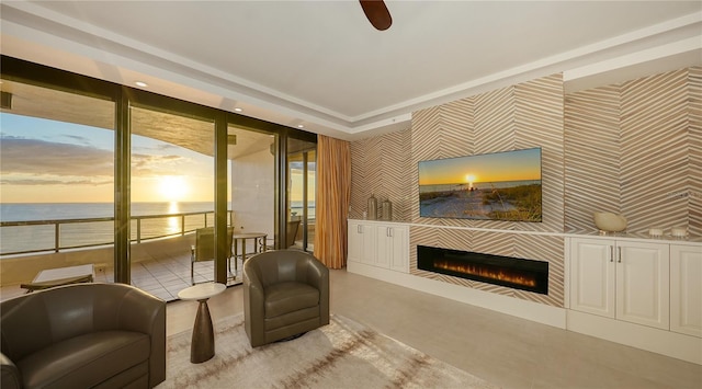 sitting room featuring ceiling fan and a water view